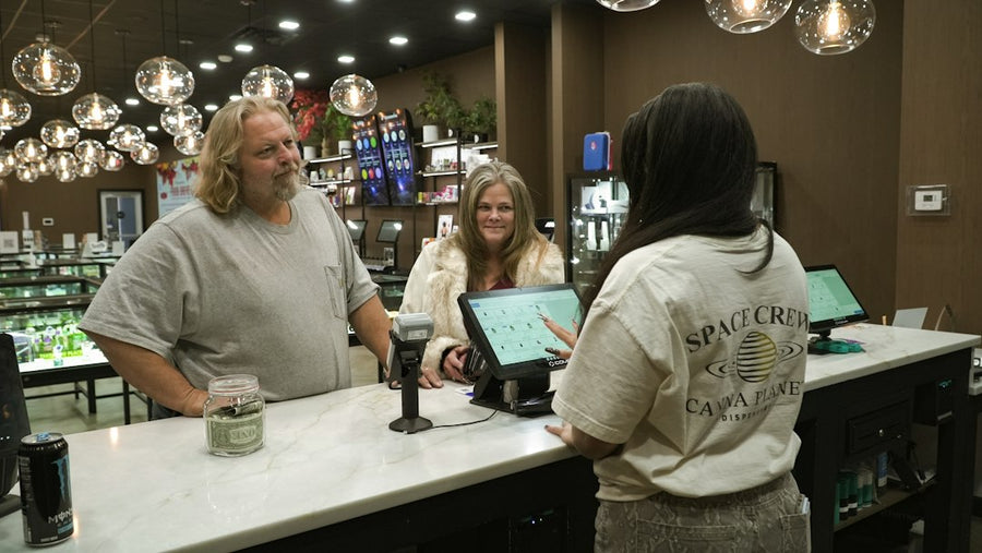 Customers interact with staff at a dispensary counter
